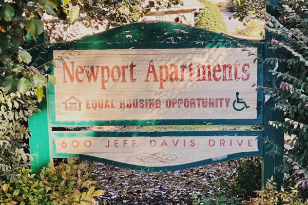 Entry way sign for Newport Apartments, a housing complex New Day members live in.